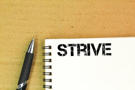 pen and book with the word strive. the concept of effortの写真素材