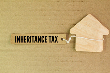 house shape and colored paper with the word Inheritance Tax. concept of inheritance taxの写真素材