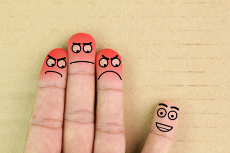 finger smileys with faces. Fingers art of people. Concept of loneliness, allocation from crowd. the concept of one successful and two jealous. angry facialの写真素材