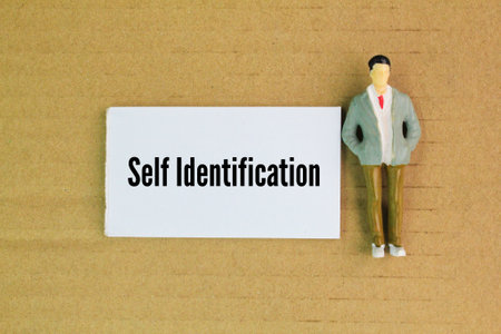 miniature people and white paper with the word self identification. defining one's own identity based on personal, social, and cultural aspectsの写真素材