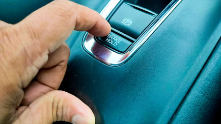 electronic car break hold button. Finger pressing the car brake button or button brake hold is a modern car safety system.の写真素材