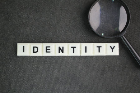magnifying glass and letters of the alphabet with the word identity. the fact of being who or what a person or thing is.の写真素材