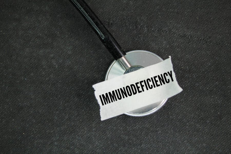 stethoscope and sticker with the word immunodeficiency. a condition in which the immune system's ability to fight infectious diseases is compromised or completely absent.の写真素材