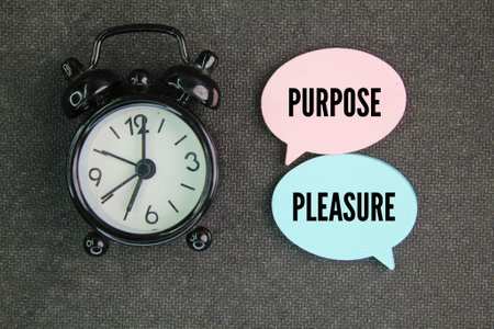 bell clock with the words purpose and pleasure. finding a balance where both can coexist and complement each other.の写真素材