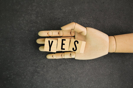 wooden hand with the word yes. the concept of a correct or true answer. concept of understandingの写真素材