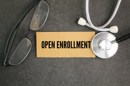 stethoscope and glasses with the word open enrollment on paperの写真素材