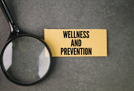 magnifying glass and paper with the words wellness and prevention. attitudes and active decisions made by an individual that contribute to positive health behaviorsの写真素材