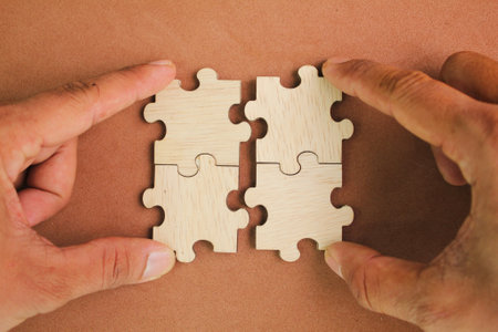 Puzzles are arranged and hands hold the last puzzle to combine. solution concept. concept of coalition or team. finishing task. Concept of solve problem and success planの写真素材