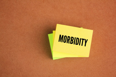 colored paper with the word morbidity. the condition of suffering from a disease or medical conditionの写真素材