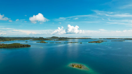 Aerial view of tropical island with turquoise water and white cloudsの写真素材