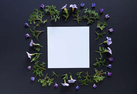 Artistic mockup for your artwork with beautiful flowers and leaves and empty card shot from the top. Flat lay minimalistic composition.の写真素材