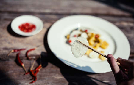 Thai exotic salad with chili pepper, mango and daikon - chinese radish on rustic wooden background. Authentic asian cuisine closeup.の写真素材