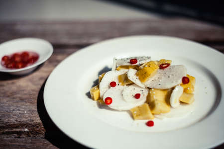 Thai exotic salad with chili pepper, mango and daikon - chinese radish on rustic wooden background. Authentic asian cuisine closeup.の写真素材