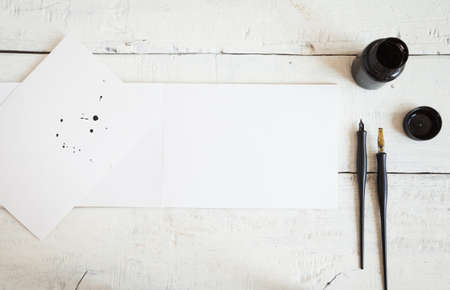Empty sketchbook on wooden desk with orchid flowers around. Mockup for elegant design.の写真素材