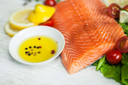 Closeup of fresh raw salmon fillet on wooden rustic table with shallow septh of field. Healthy food, diet or cooking concept.の写真素材