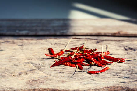 Dryied chili peppers on a wooden background. Spicy food ingredient.の写真素材