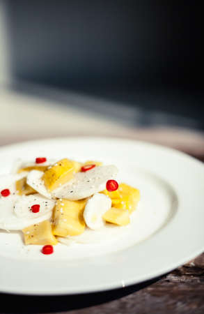 Thai exotic salad with chili pepper, mango and daikon - chinese radish on rustic wooden background....