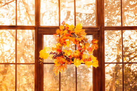 Autumn wreath, hanging on the wooden window. Evening time. Closeupの写真素材