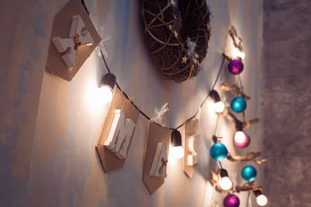Cristmas garland with word Xmas and lightning bulbs. Winter wreath, creative decorated New Year tree.の写真素材