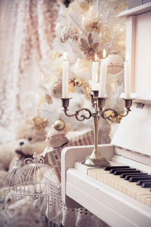 Christmas background. Xmas scene. White piano and burning candles.の写真素材