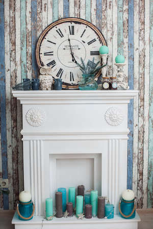 Fireplace at the multicolored boards wallpaper with turquoise hue candles.の写真素材