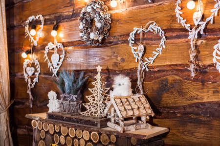 Winter holiday background, wooden hearts, bird box, decorative Christmas tree.