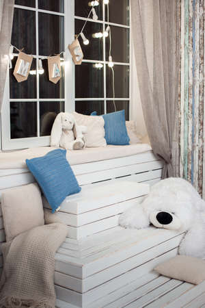 White pyramidal wooden staircase leading to windows with bulbs garland. Christmas backgroundの写真素材