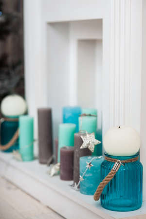 turquoise, mint, brown candles in fireplace portal. Horizontalの写真素材