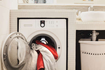 Washing machine with multicolored dirty towels inside. Horizontalの写真素材