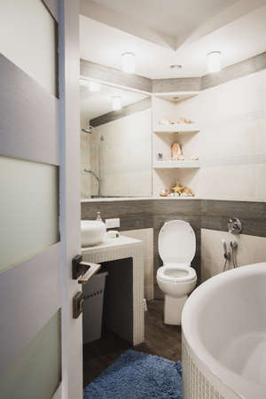 Interior design of a luxury bathroom, washroom with washbasin (sink), bathtub, huge mirror and seashells on the counter.の写真素材