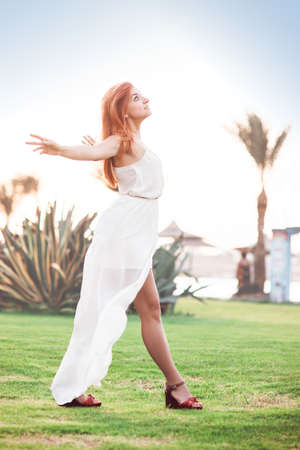 Attractive girl dressed in white waiting to the rain and look at the sky in african resort.の写真素材