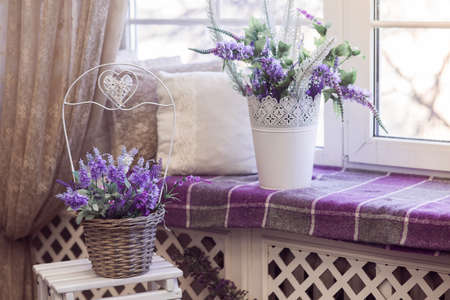 Lavender flowers in white pots and and wicker baskets stands on the windowsill. Horizontalの写真素材