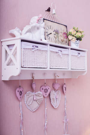 White rack with valentine days symbols on pink wall in bedroom. Verticalの写真素材
