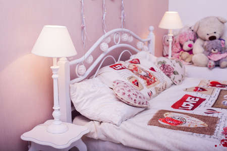 Head of valentines style bed with glowing lamps on the sides of it. Love and Valentine's day concept. Side view. Horizontalの写真素材