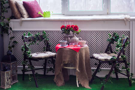 two chairs and a table served for tea time entwined with green ivy. Romantic tea party. Horizontalの写真素材
