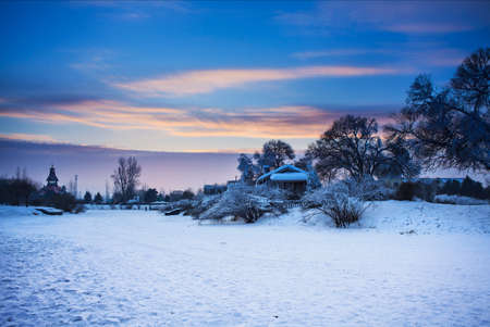 Farmhouse with snow during sunsetの写真素材