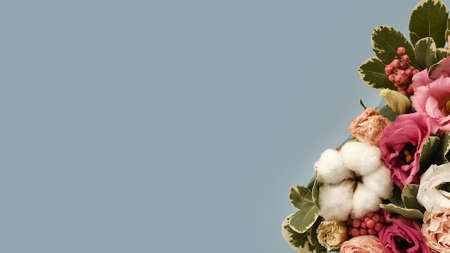 Bouquet of flowers on side in rustic style on blue background. Spring flowers. Geometric design. Banner design. Background for presentation. Copy space. Bouquet element.の写真素材