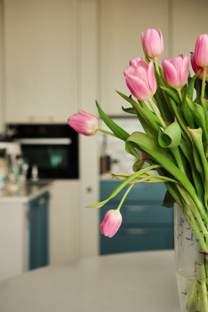 Beautiful closeup of bouquet of pink delicate tulips at kitchen. Holiday floral decor. Selective focus. Copy space. Elegant decoration. Natural background. Spring flowers. Romantic background.の写真素材