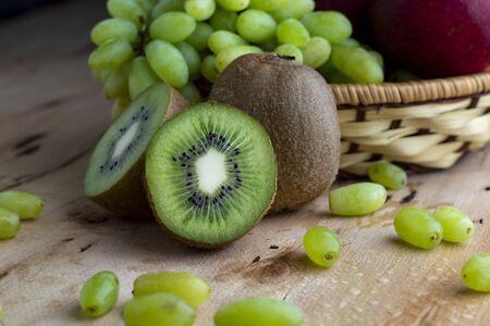 Grape fruit with kiwi fruit on a wooden table - Imageの写真素材