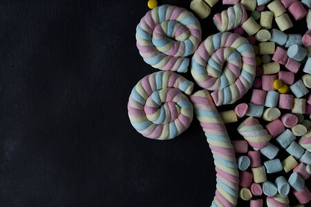 Marshmallows. of colorful mini marshmallows,top view  on a black background ,  With space to...
