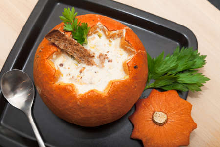 Cheese soup in a pumpkin on a plateの写真素材