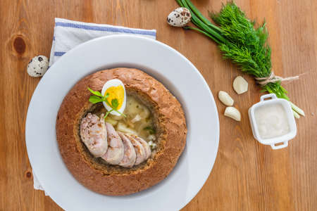 traditional white borscht zurek with sausage,egg and mushrooms in bread as bowlの写真素材