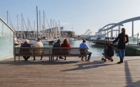 people sit on a bench and look at the water.の写真素材