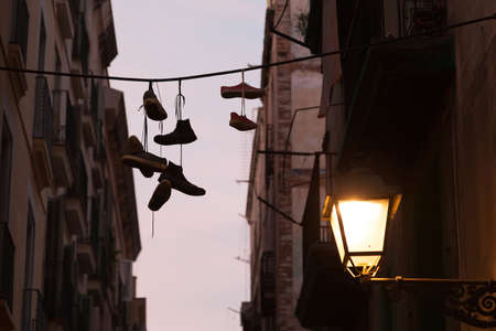 Dirty Sneakers hanging on the clothesline silhouette.の写真素材