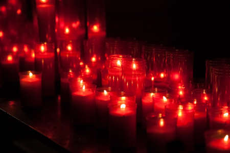 Red candles row bokeh in the darkの写真素材