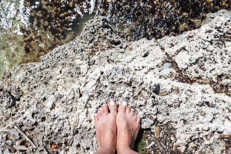 Woman bare feet stand on stone, view from topの写真素材