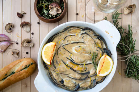 Mussels backed in cream sauce with rosemary on wood background.の写真素材