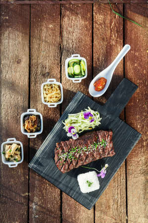 Korean BBQ with full side dishes on wooden backgroundの写真素材