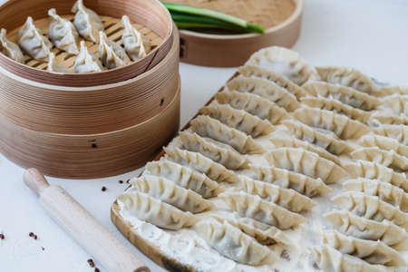 Raw Homemade Chinese Dumplings on Wooden Board.の写真素材