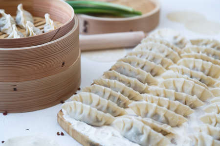 Raw Homemade Chinese Dumplings on Wooden Board.の写真素材
